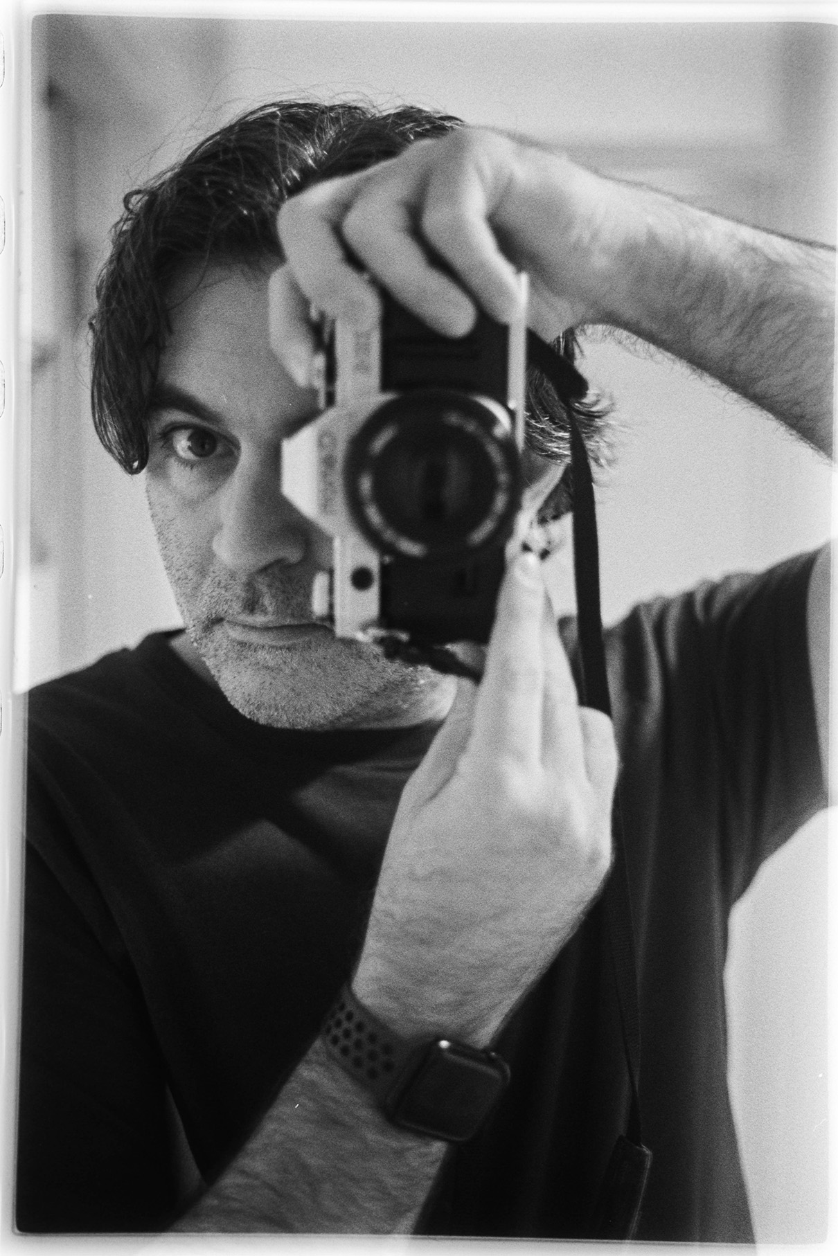 Claudio Gomboli photographing himself in a mirror with a film camera